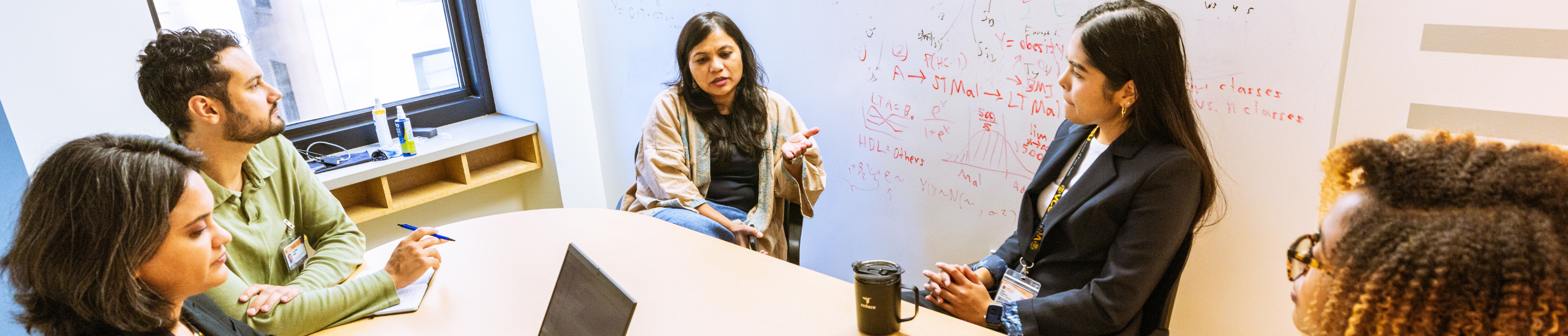 Students and a professor talking around a table